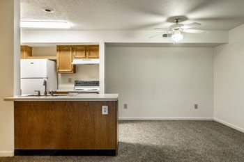 A kitchen with a white fridge and wooden cabinets.
